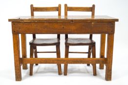 A child's oak finish double school desk with inset porcelain ink wells and pen recesses,