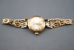 A hallmarked 9ct yellow gold rotary watch with gate link bracelet. 21 jewelled manual wind movement.