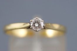 A yellow and white metal single stone diamond ring.