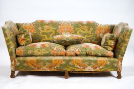 A three seater sofa with raised crested back and arms set with two base and three back cushions,