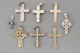 A collection of eight silver cross pendants of variable designs.