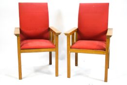 A pair of 20th century oak framed armchairs, upholstered in red,