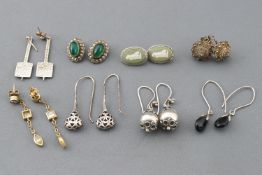 A collection of eight pairs of earrings of variable designs and with mixed metals.