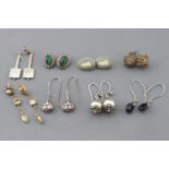 A collection of eight pairs of earrings of variable designs and with mixed metals.