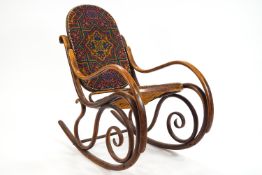 A bentwood rocking chair with carpet seat and back,the sides of contrived S scroll design,