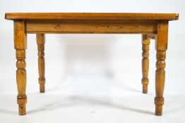 A pine table with one frieze drawer on turned legs,