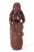 A Japanese carved wood Netsuke of a mermaid, sat on a rocky outcrop,