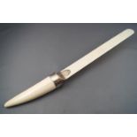 A silver mounted ivory paper flip, the handle in the form of a tusk, the mount London 1923,