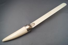 A silver mounted ivory paper flip, the handle in the form of a tusk, the mount London 1923,