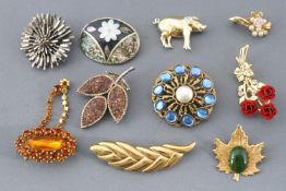 A collection of twenty costume brooches of variable designs.