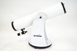 A Sky Watcher telescope on a Dobsonian mount with a box of accessories