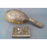 A silver handled hairbrush, profusely decorated with a hunting scene of the kill, Birmingham 1903,