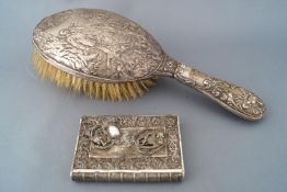 A silver handled hairbrush, profusely decorated with a hunting scene of the kill, Birmingham 1903,