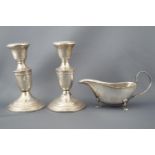 A pair of silver plated candlesticks (13cm high),