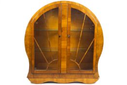 An Art Deco walnut veneered 'Sun Burst' display cabinet, of rounded form,