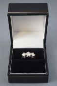 A white metal three stone ring,