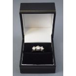 A white metal three stone ring,