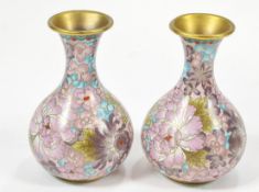 A pair of pink cloisonne vases, decorated with flowers on a pink ground,