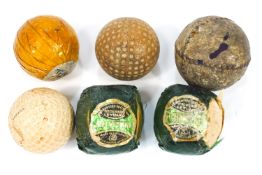 A collection of early golf balls, including a leather stitched example,