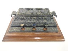 A Victorian cast iron inkwell , on a mahogany plinth base,