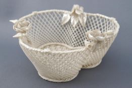 A Belleek triple lobed basket, the rim with encrusted flowers,