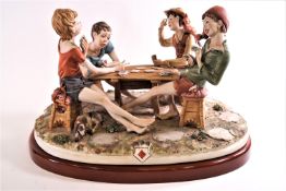 A Capodimonte figure, 'Cheats', in the form of four boys playing cards at an outdoor table,