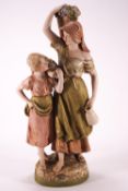 A Royal Dux figure group of grape carriers, the two ladies carrying the baskets on their shoulders,