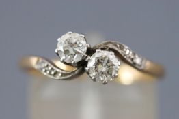 A yellow and white metal diamond ring set with two round brilliant cut diamonds