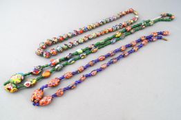 A collection of three beaded necklaces with painted millefiori design.