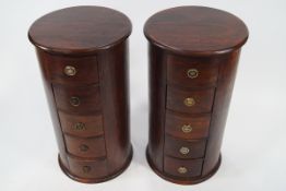 A pair of hardwood cylinder chests of five drawers, with ring handles,