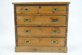 A pine chest of drawers with a plain rectangular top with rounded corners over four long drawers