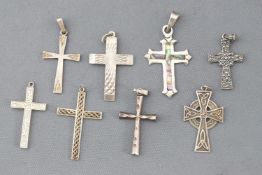 A collection of eight silver cross pendants of variable designs.