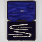 A cased set of two plated nut crackers and two nut picks, retailed by G Falconer & Co,