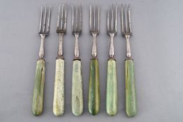 A set of six 18th century steel knives and forks with green stained ivory handles