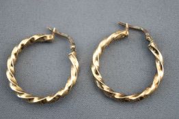 A yellow metal pair of twisted creole earrings. No hallmark - tests indicate 9ct gold.