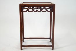 A Chinese hardwood side table with a rectangular framed top over a pierced and shaped frieze