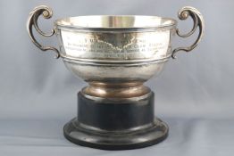 A silver two handled trophy rose bowl, of plain form with a banded body, raised on a pedestal foot,