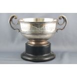 A silver two handled trophy rose bowl, of plain form with a banded body, raised on a pedestal foot,