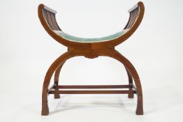 An Edwardian mahogany X frame stool with green upholstered seat,