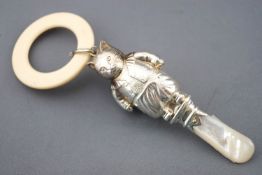 A silver rattle in the form of Tom Kitten with a mother of pearl handle and a teething ring,