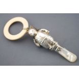 A silver rattle in the form of Tom Kitten with a mother of pearl handle and a teething ring,