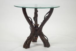 A Black Forest carved wood tripartite table stand realistically carved as branches,