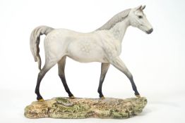 A Royal Doulton matt glazed figure of a grey horse, on naturalistic rocky base, 33cm wide,