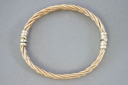 A yellow and white metal heavy twisted bangle. Push in clasp. Diameter: 65.0mm.