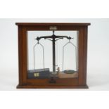 A wooden cased set of laboratory scales, of usual form and attendant weights,