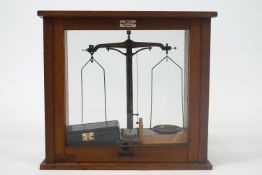 A wooden cased set of laboratory scales, of usual form and attendant weights,