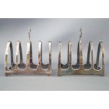 A pair of silver small form toast racks, of simple pointed Gothic arch form with a strap handle,