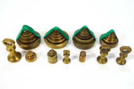 Four sets of stacking brass weights together with seven assorted brass weights