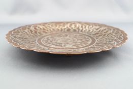 A Middle Eastern silver damascened copper circular dish with a lobed edge,