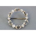 A white metal wreath brooch set with six old brilliant cut diamonds